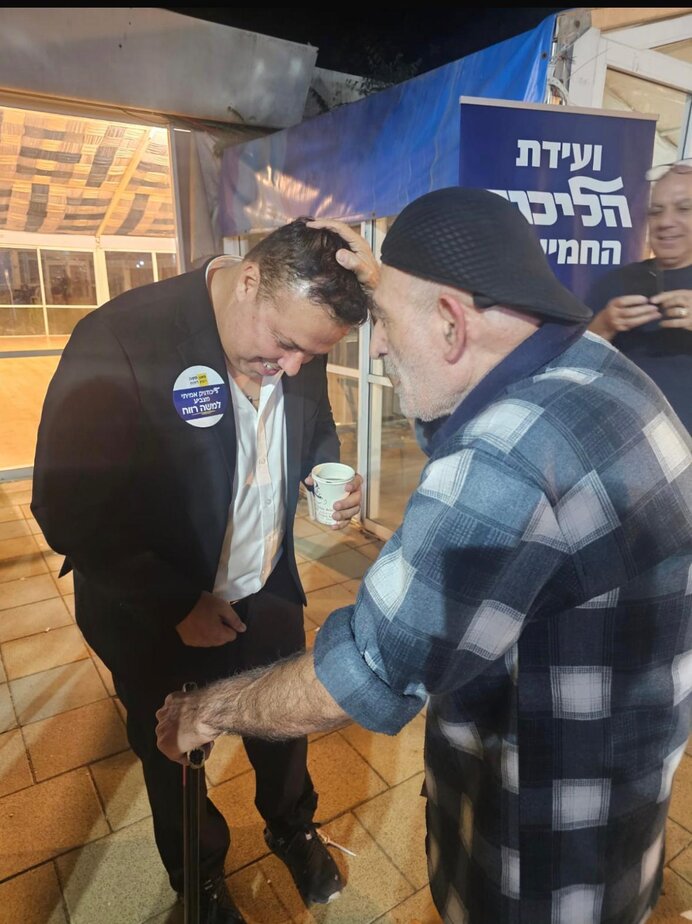 משה רווי מקבל ממתפקד הליכוד ברכה להצלחה לפני שהוא נכנס לקלפי. צילום: חיים נחמיאס