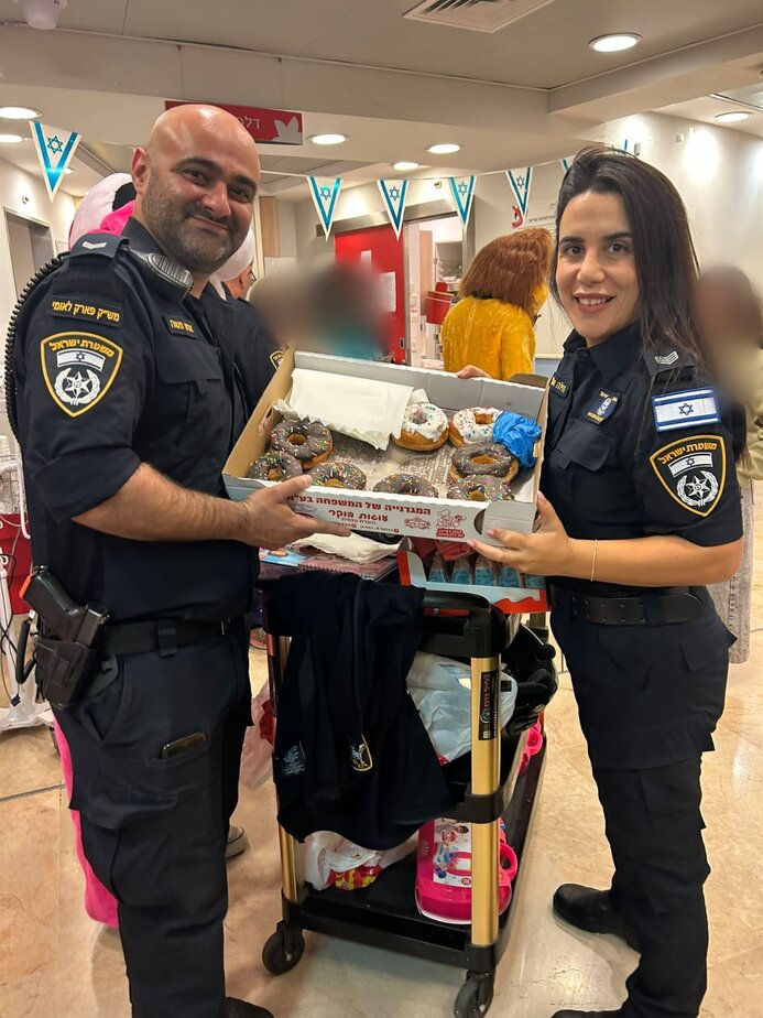 שוטרי תחנת בני ברק-רמת גן מחלקים סופגניות בשיבא. צילם: דוברות משטרת ישראל