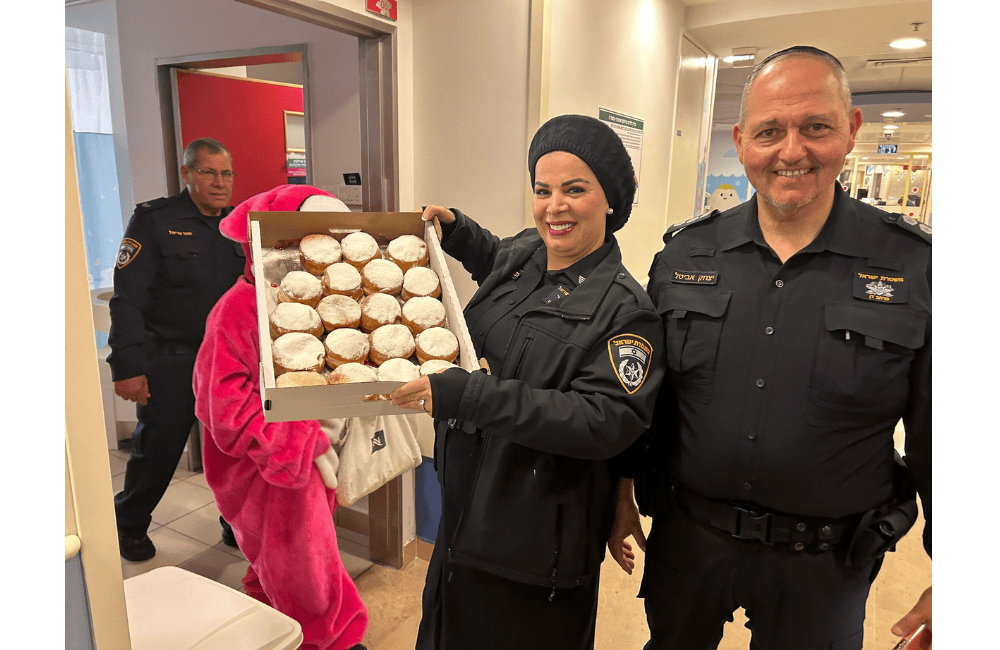 שוטרי תחנת בני ברק-רמת גן מחלקים סופגניות בשבא. צילם: דוברות משטרת ישראל